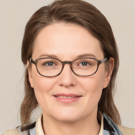 Joyful white adult female with medium  brown hair and blue eyes