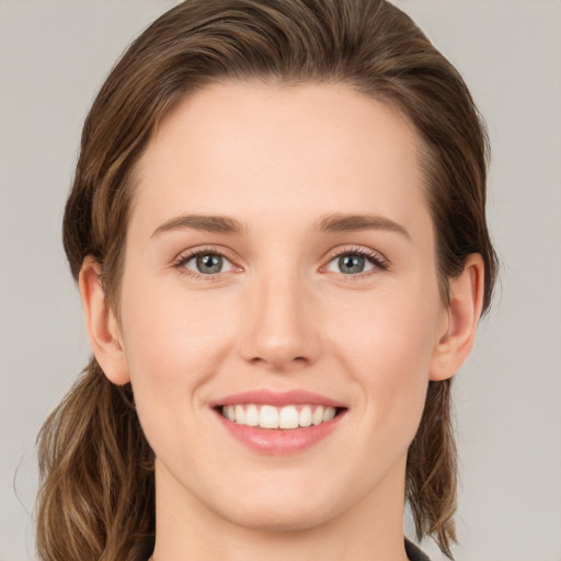 Joyful white young-adult female with medium  brown hair and green eyes