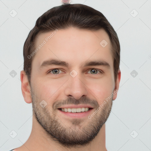 Joyful white young-adult male with short  brown hair and grey eyes