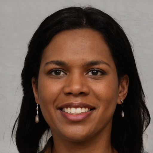 Joyful black young-adult female with long  black hair and brown eyes