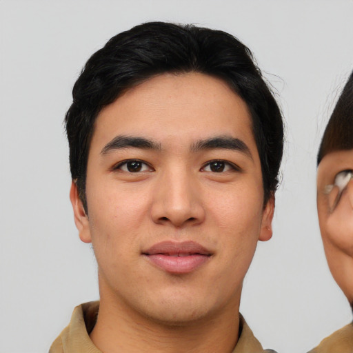 Joyful asian young-adult male with short  black hair and brown eyes