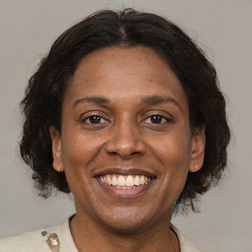 Joyful latino adult female with medium  brown hair and brown eyes