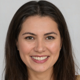 Joyful white young-adult female with long  brown hair and brown eyes