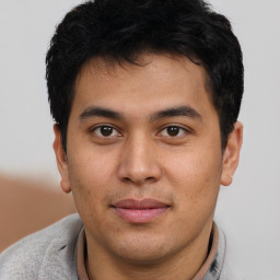 Joyful latino young-adult male with short  brown hair and brown eyes