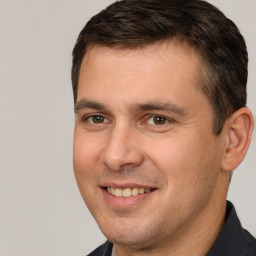 Joyful white adult male with short  brown hair and brown eyes