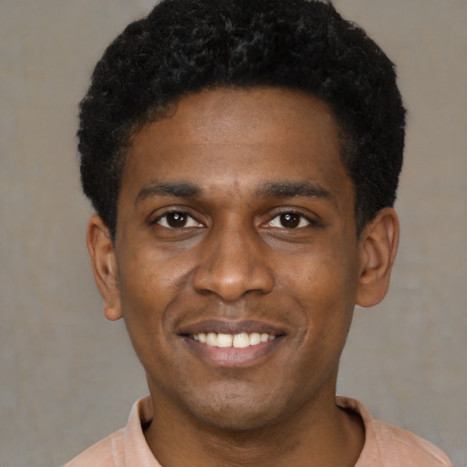 Joyful black young-adult male with short  black hair and brown eyes