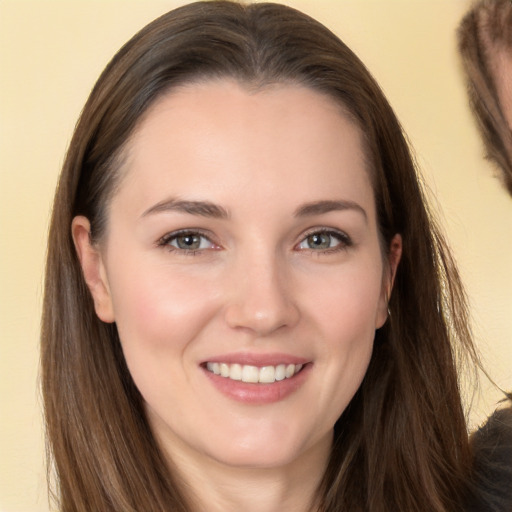 Joyful white young-adult female with long  brown hair and brown eyes