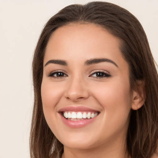 Joyful white young-adult female with long  brown hair and brown eyes