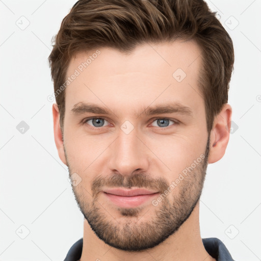 Joyful white young-adult male with short  brown hair and grey eyes