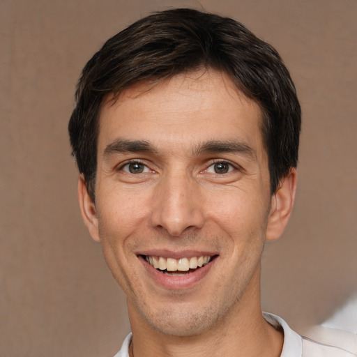 Joyful white young-adult male with short  brown hair and brown eyes