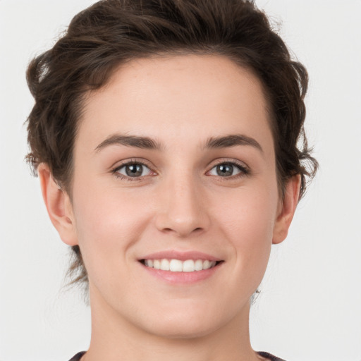 Joyful white young-adult female with short  brown hair and green eyes