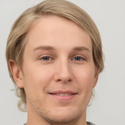 Joyful white young-adult male with medium  brown hair and grey eyes