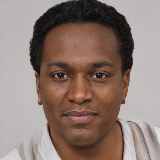 Joyful black young-adult male with short  black hair and brown eyes