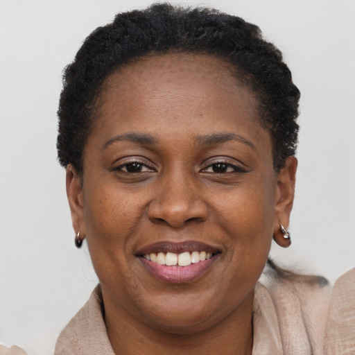 Joyful black adult female with short  brown hair and brown eyes