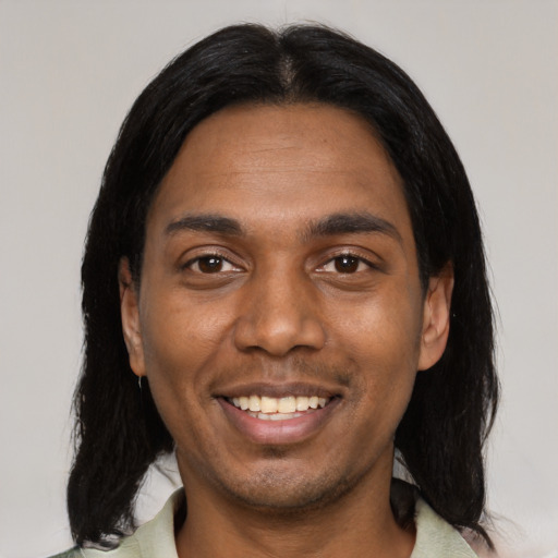 Joyful black young-adult male with medium  black hair and brown eyes