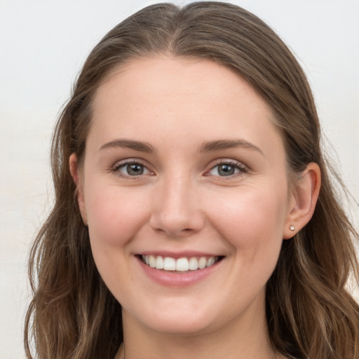 Joyful white young-adult female with long  brown hair and grey eyes