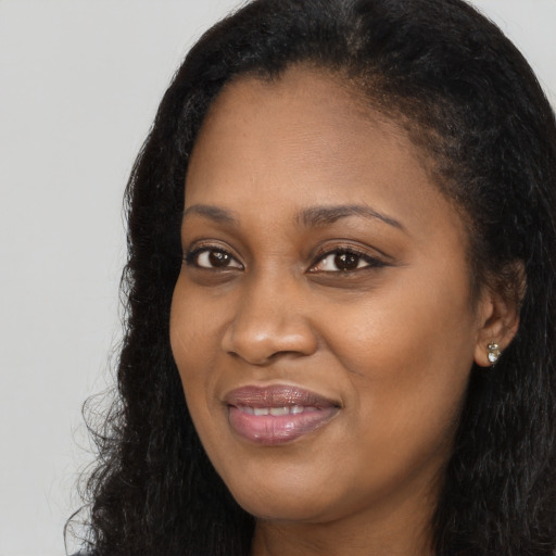 Joyful black young-adult female with long  black hair and brown eyes
