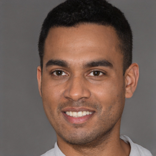 Joyful black young-adult male with short  black hair and brown eyes