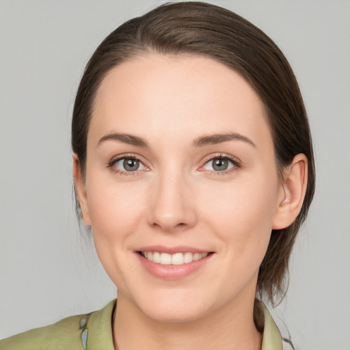 Joyful white young-adult female with medium  brown hair and green eyes