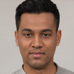 Joyful latino young-adult male with short  black hair and brown eyes