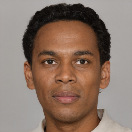 Joyful black young-adult male with short  black hair and brown eyes