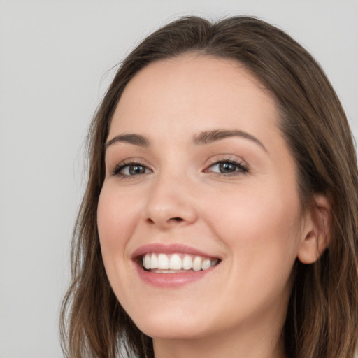 Joyful white young-adult female with long  brown hair and blue eyes