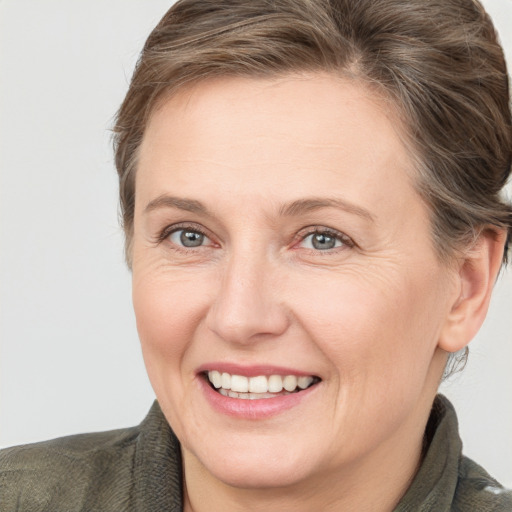 Joyful white adult female with medium  brown hair and grey eyes