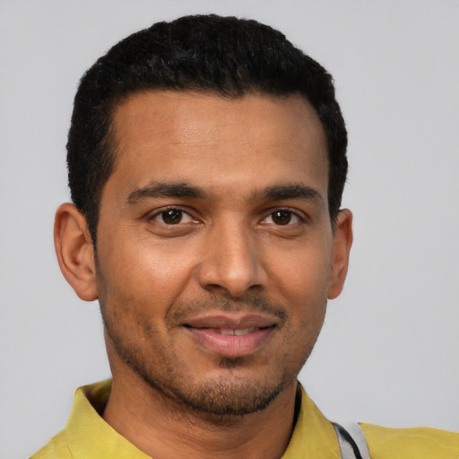 Joyful latino young-adult male with short  black hair and brown eyes