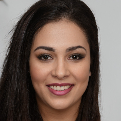Joyful white young-adult female with long  brown hair and brown eyes