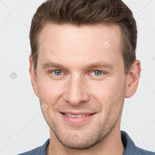 Joyful white young-adult male with short  brown hair and grey eyes