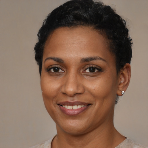 Joyful black young-adult female with short  brown hair and brown eyes