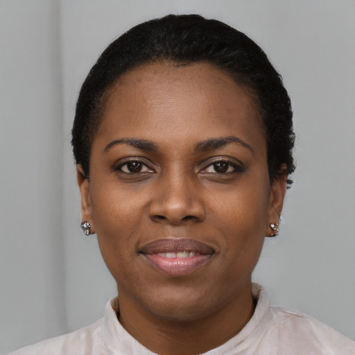Joyful black young-adult female with short  black hair and brown eyes