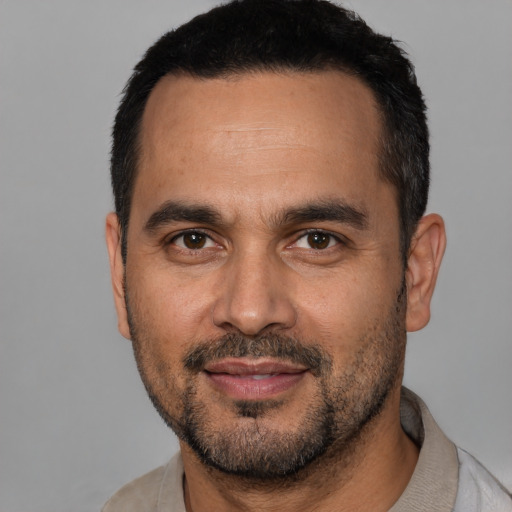 Joyful white adult male with short  black hair and brown eyes