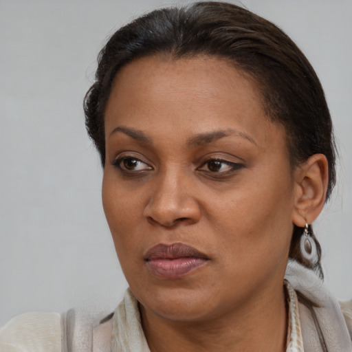 Joyful black adult female with medium  brown hair and brown eyes