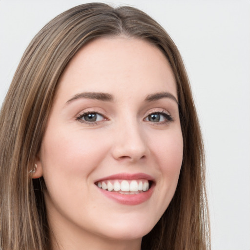 Joyful white young-adult female with long  brown hair and green eyes