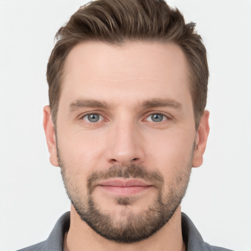 Joyful white young-adult male with short  brown hair and grey eyes