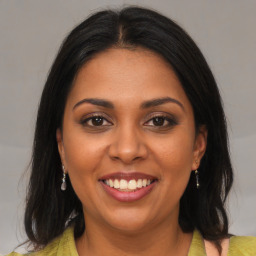 Joyful black young-adult female with medium  brown hair and brown eyes