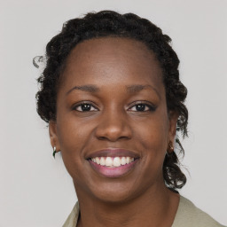 Joyful black young-adult female with long  brown hair and brown eyes