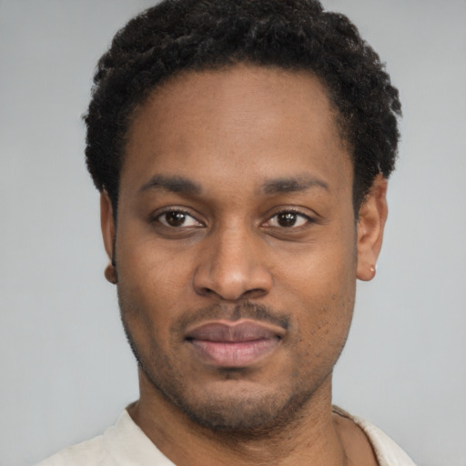 Joyful black young-adult male with short  black hair and brown eyes