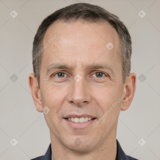 Joyful white adult male with short  brown hair and brown eyes