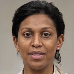 Joyful black adult female with medium  brown hair and brown eyes