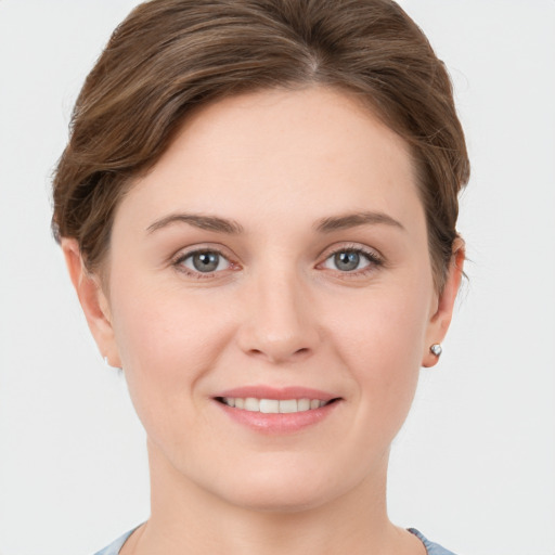 Joyful white young-adult female with short  brown hair and grey eyes