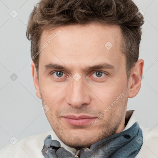 Joyful white adult male with short  brown hair and grey eyes