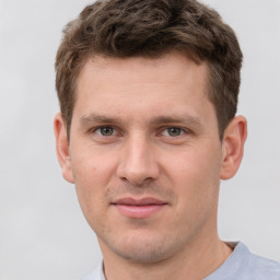 Joyful white young-adult male with short  brown hair and grey eyes