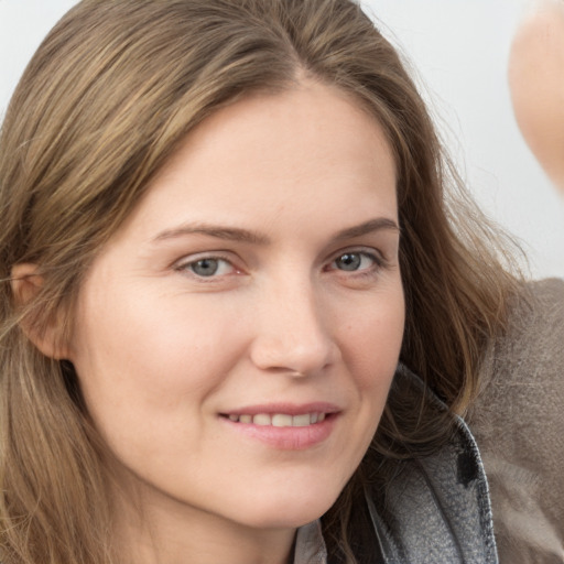 Joyful white young-adult female with long  brown hair and grey eyes