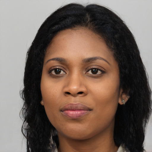 Joyful black young-adult female with long  black hair and brown eyes