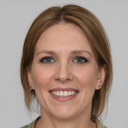 Joyful white adult female with medium  brown hair and grey eyes