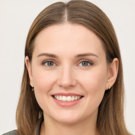 Joyful white young-adult female with long  brown hair and green eyes