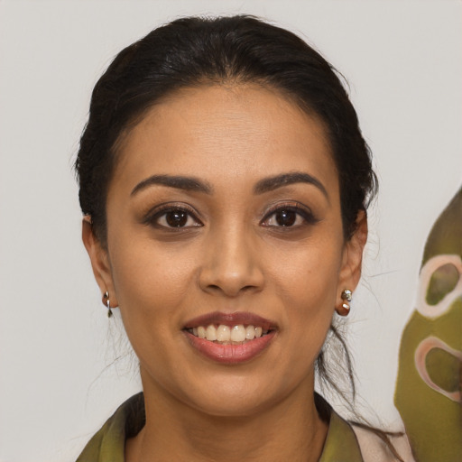 Joyful latino young-adult female with medium  brown hair and brown eyes