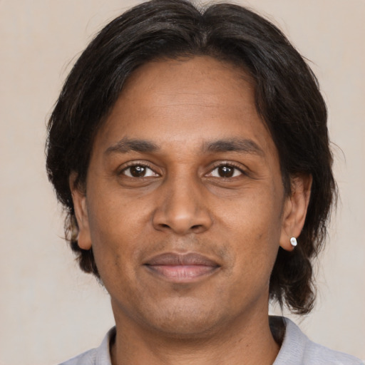 Joyful black adult male with medium  brown hair and brown eyes